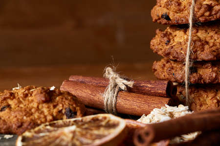 Christmas composition with sweet chocolate biscuits tied up with a ribbon, cinnamon sticks and dried...