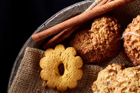 Conceptual composition with assortment of cookies, cinnamon sticks bunch and dried oranges on a...