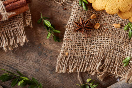 Conceptual composition with assortment of cookies, cinnamon sticks bunch and dried oranges on a...