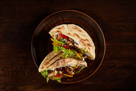 Tasty Jewish pita stuffed with grilled chicken, vegetables, beans, letucce and sauce on...