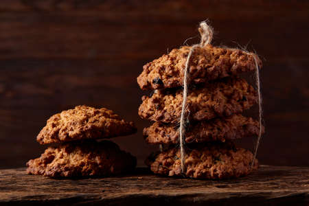 Conceptual composition with assortment of cookies, cinnamon sticks bunch and dried oranges with burlap napkin on a wooden barrel over rustic background, selective focus, close-up. Delicious treat. Relaxing teatime. Christmas background.の写真素材
