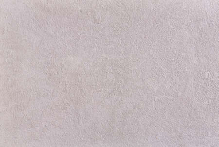 Close-up surface detail of old rough white plaster wall texture, macro. Empty light scratches effect background for architecture material and interior decoration concepts, vintage and modern style. Some open space for text or inscription.の写真素材