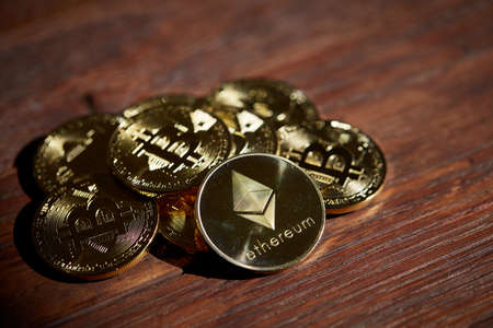 Ethereum on the pile of cryptocurrency over wooden table as most important cryptocurrency concept, close-up, selective focus. Cryptocurrency mining. Virtual business. Electornic commerce. Banking monetary. Cryptocurrency diversification.の写真素材