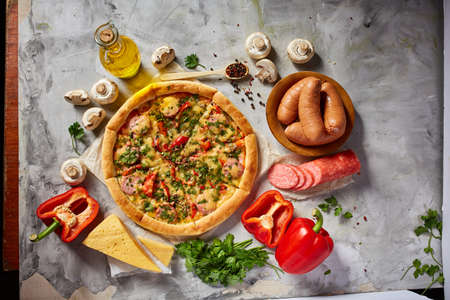 Tasty Italian pizza and its ingredients on white textured background, top view, close-up, selective focus. Delicious snack. Traditional homemade Italian pizza. Mediterranian cuisine. Fast food concept.の写真素材
