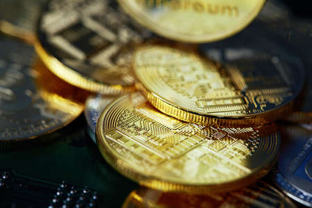 Stack of cryptocurrencies arranged on the motherboard. Bitcoin as most important cryptocurrency concept, close-up, selective focus. Cryptocurrency mining. Virtual business. Electornic commerce. Banking monetary. Cryptocurrency diversification.の写真素材