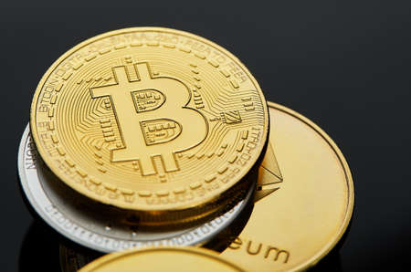 Conceptual image of different cryptocurrency with bitcoins on dark table, close-up, selective focus, front focus, shallow depth of field. Cryptocurrency concept. Physical bit coin. Digital currency. Cryptocurrency. Golden coin with bitcoin symbol.の写真素材