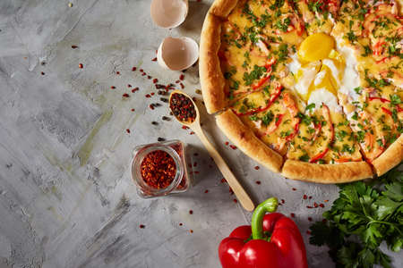 Part of tasty Italian pizza, pepper, parsley and cheese on white textured background, top view, close-up, selective focus. Delicious snack. Traditional homemade Italian pizza. Mediterranian cuisine. Fast food concept.の写真素材