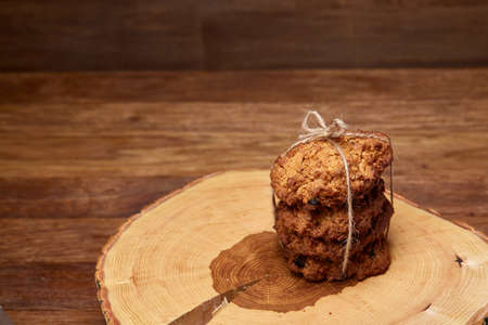 Conceptual composition with assortment of cookies, cinnamon sticks bunch and dried oranges with burlap napkin on a wooden barrel over rustic background, selective focus, close-up. Delicious treat. Relaxing teatime. Christmas background.の写真素材