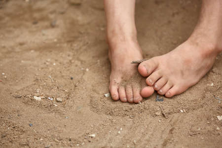 Dirty bare feet of poor little girl in the street dust, selective focus, shallow depth of field. Small toes of abandon street kid. Poverty among us. Homeless children. Cruel world. Much needed care and mercy. Blatantly poverty and poorness.の写真素材