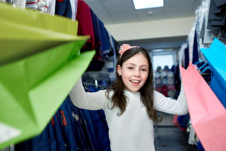 cute little girl on shopping. portrait of a kid with shopping bags. child in dress, sunglasses and shoes near shopping mall having fun. shoppingの写真素材