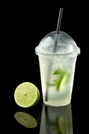 Lemonade to go cup with mint, lime and kiwi on black background, isolated on blackの写真素材