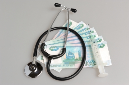 Stethoscope, syringe and money on gray backgroundの写真素材