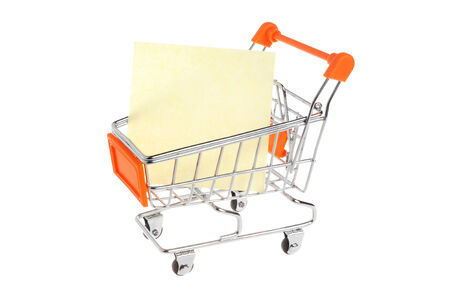 Blank paper sheet in shopping cart isolated on white backgroundの写真素材