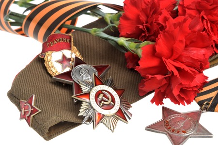 Military cap with red flowers, Saint George ribbon and orders of Great Patriotic war isolated