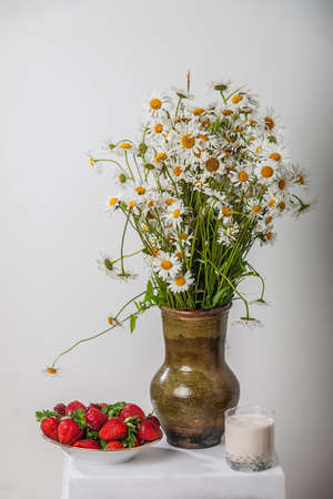 Daisies in a Krynka, strawberries with milk の写真素材