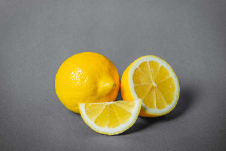 Fresh organic illuminating yellow lemon lime citrus fruit with slice on ultimate gray background....