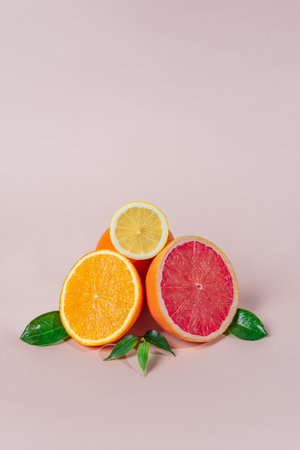 citrus fruits, grapefruits, mandarins, lemons, oranges, with green leaves lie on a light background.の写真素材