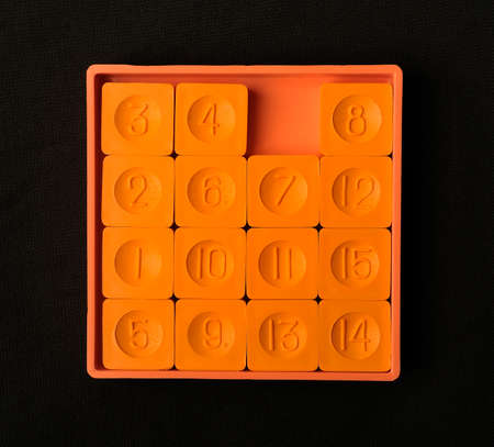 Pocket sliding fifteen puzzle game orange color on a dark background
