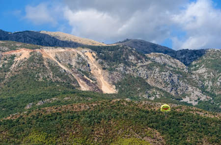 People fly by parachute against the backdrop of the mountainsの写真素材