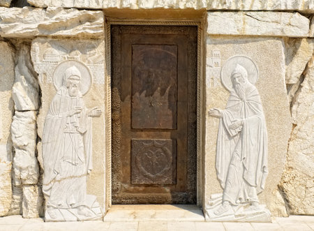 Montenegro, Podgorica - August 10, 2017: elements of decor and architecture of the Cathedral of the Resurrection of Christ, a door with a picture of biblical plotsのeditorial素材