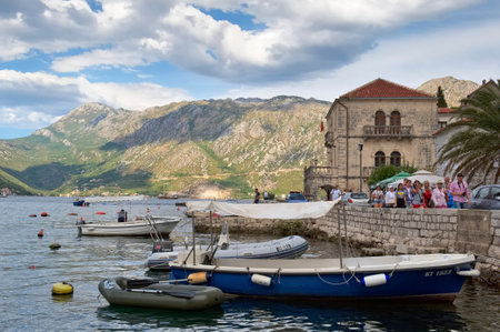 Montenegro, Perast - August 13, 2017: Tourists go along the embankment of Perast, in the background the Palace of Buyovichesのeditorial素材