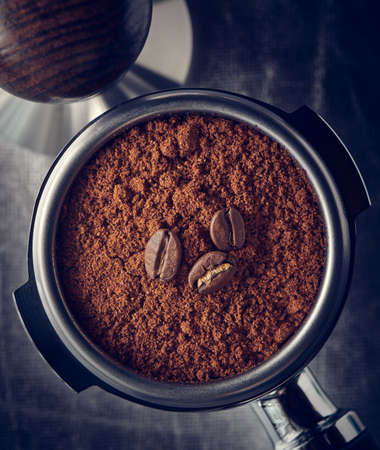Ground coffee and beans in portafilter, tinted, close upの写真素材