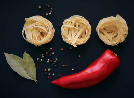 Raw round pasta, bay leaves, sweet bulgarian pepper. The concept of cooking. Top view, flat layの写真素材
