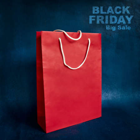 Black Friday. Red gift paper bag on blue backgroundの写真素材