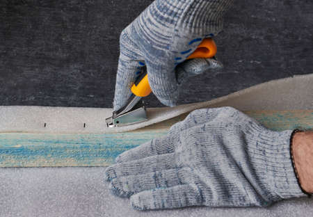 Worker removes upholstery brackets from furniture stapler, shallow depth of fieldの写真素材