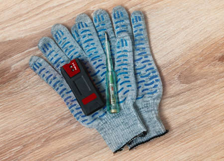 Electrician or Builder tools on a wooden background. Hidden wiring detector, screwdriver tester and...