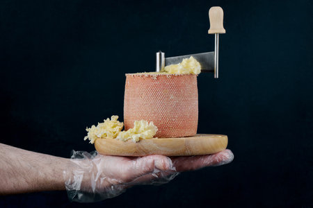 Tete de moine cheese slicer Girolle on a mans hand, cheese making concept, delicatessenの写真素材