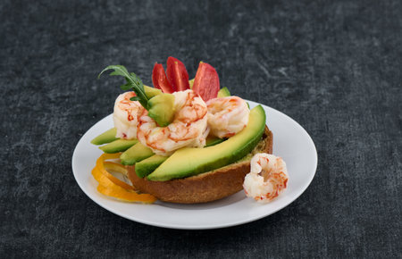 Sandwich on a rye bun with avocado, shrimp and tomato, top view, shallow depth of sharpnessの写真素材