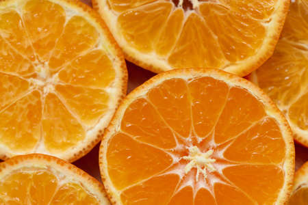 Background of fresh and juicy tangerine slices or mandarin fruit, macro, shallow depth of field