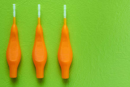 Interdental brush for interdental spaces on green background with copy space, top view, macroの写真素材
