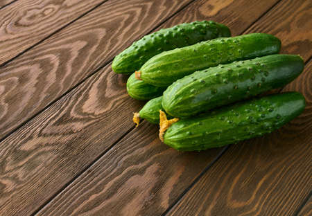 Fresh green cucumbers on a wooden table close up, with copy spaceの写真素材