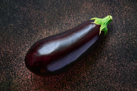Ripe raw eggplant close-up on a dark background