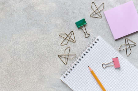 Office accessories, notebook, pencil, clerical staple, clips and sticky, flat lay with copy space