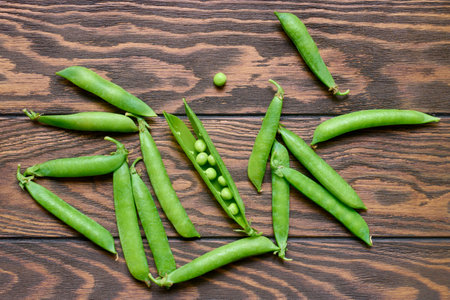 Green pea pods on wooden table, top view, close upの写真素材