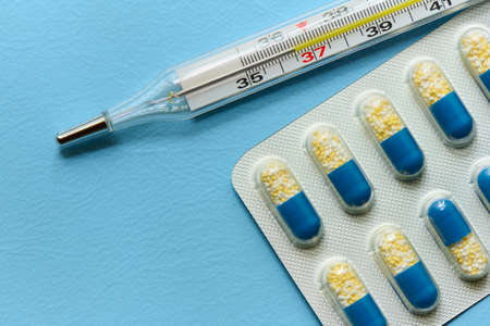 Medicine in hard gelatin capsule packed in transparent blister and thermometer