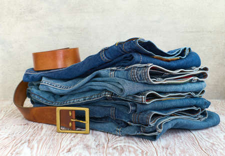 Folded jeans on wooden table close upの写真素材