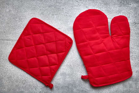 Red oven glove and potholder close up, gray background, flat layの写真素材