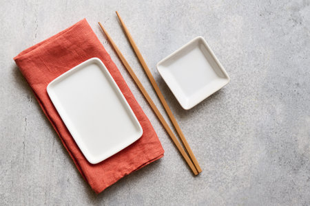 Empty white square plates with chopsticks and linen napkin, top view with copy spaceの写真素材