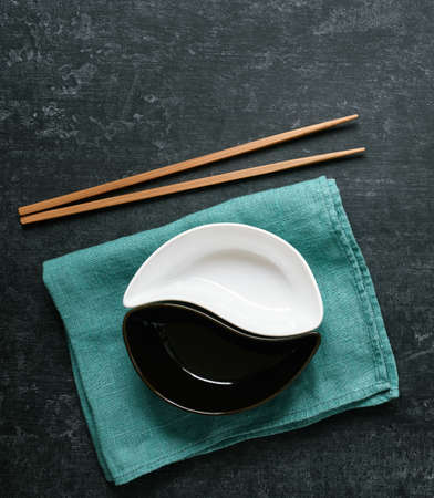 Ceramic bowls and chopsticks on a green linen napkin, flat lay, asian culture