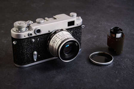 Old vintage camera and film reel close-up on dark table