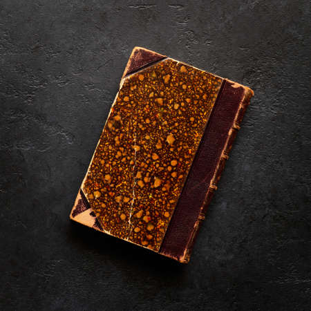 An old colorful book on a black slate background