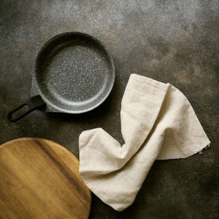 Empty serving pan, cutting board and linen napkin, top view, close upの写真素材