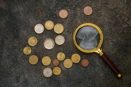 Euro cents and a magnifying glass on dark backgroundの写真素材
