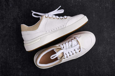 Womens athletic shoes, leather sneakers on a gray background, flat lay