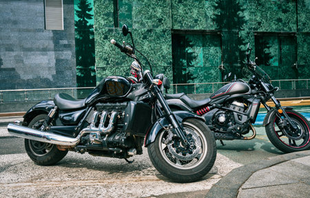 Stylish Triumph and Kawasaki motorcycles in the parking lot near the office building in Moscow City:...
