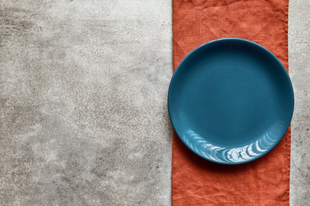 Empty blue ceramic plate on terracotta linen napkin, with copy spaceの写真素材